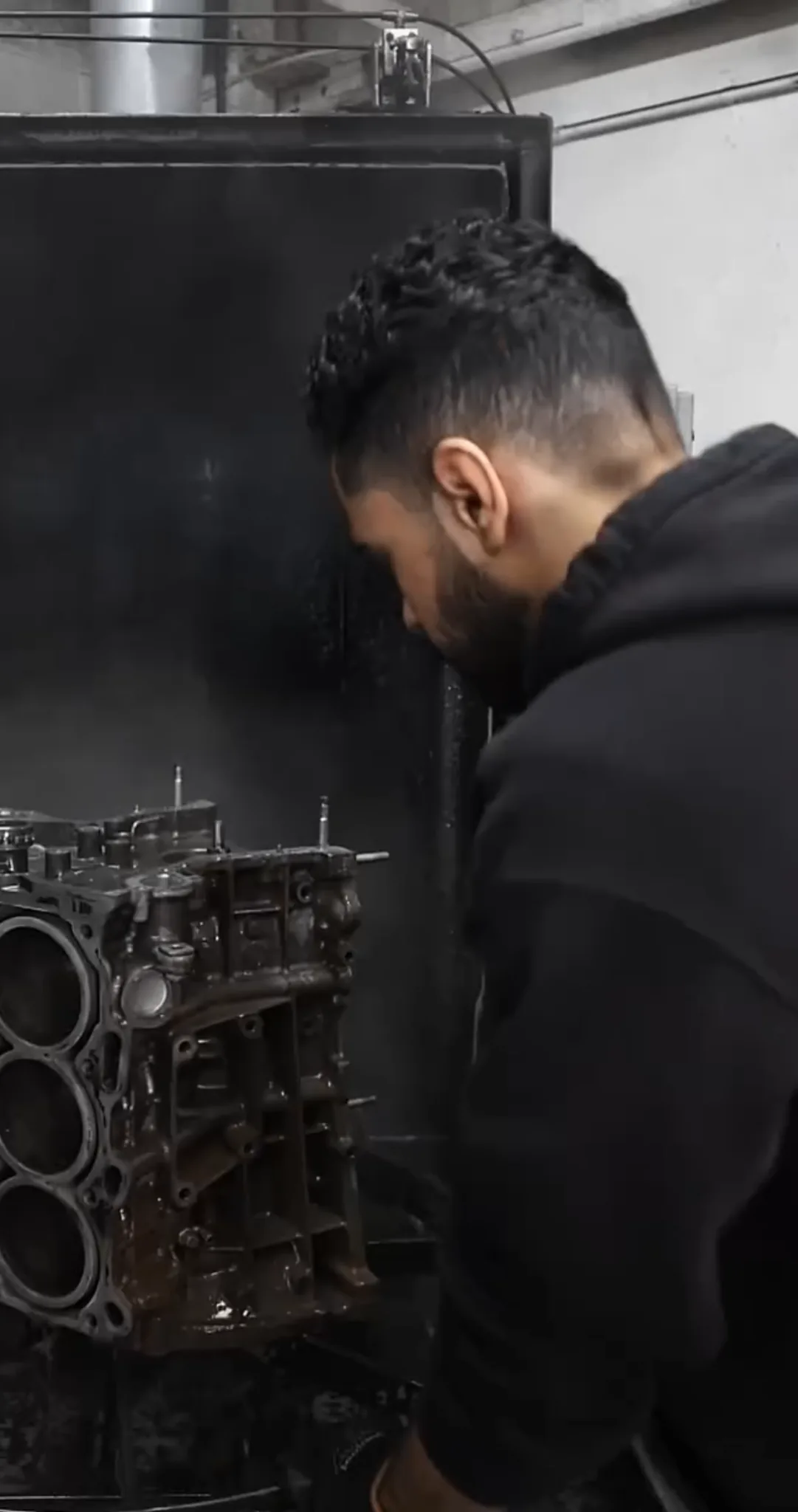 Noah cleaning an engine block at MJM Engines